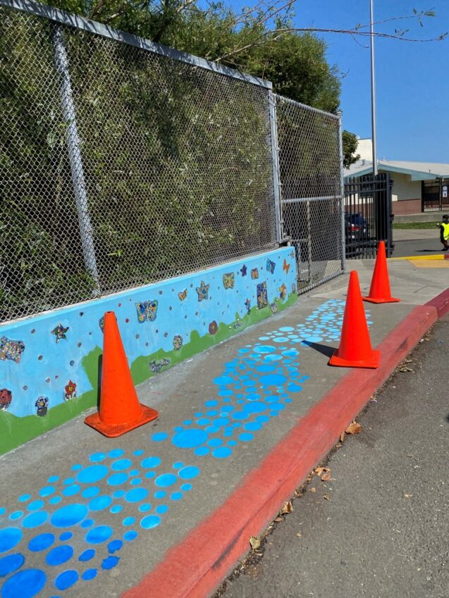 Cones around sidewalk painting