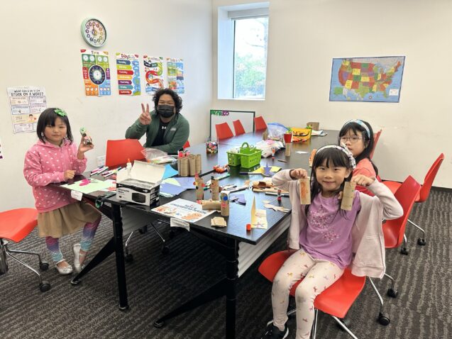 Three little girls around completed crafts.