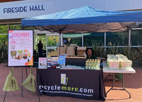 A man in a booth with RecycleMore Logo at Contra Costa College