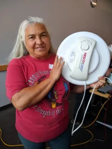 Lady holding a round white plastic object in the air