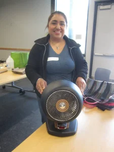 Lady with hands on black plastic fan