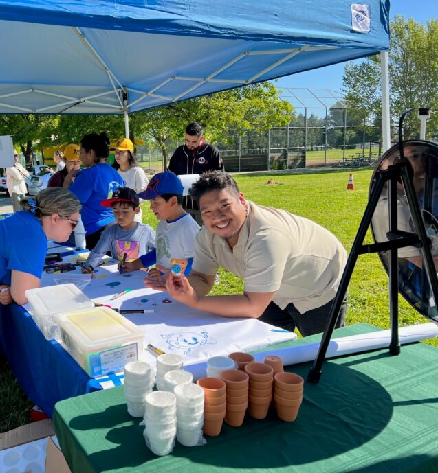 participants engage in Earth Day activities under a tent