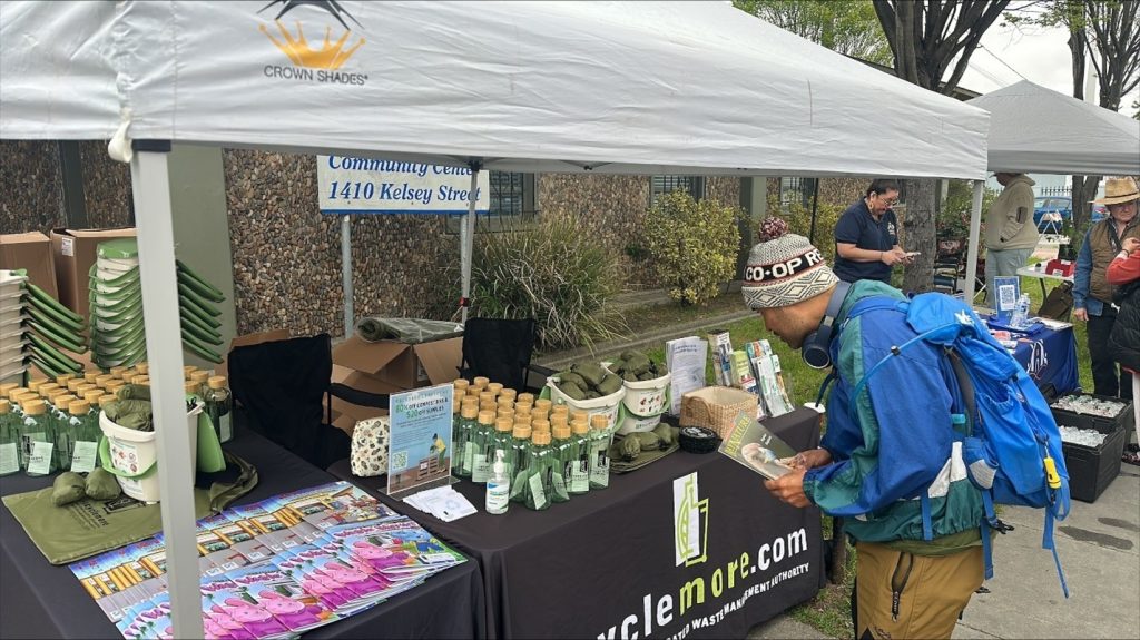 A local West Contra Costa County resident visits the RecycleMore booth to obtain information on program and resources including free RecycleMore swag, and food scrap pails. 